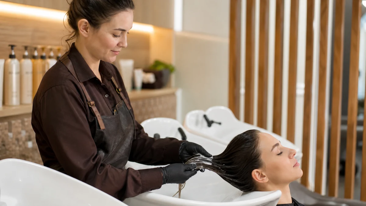 Парикмахер салона Кокетка наносит ботокс для волос